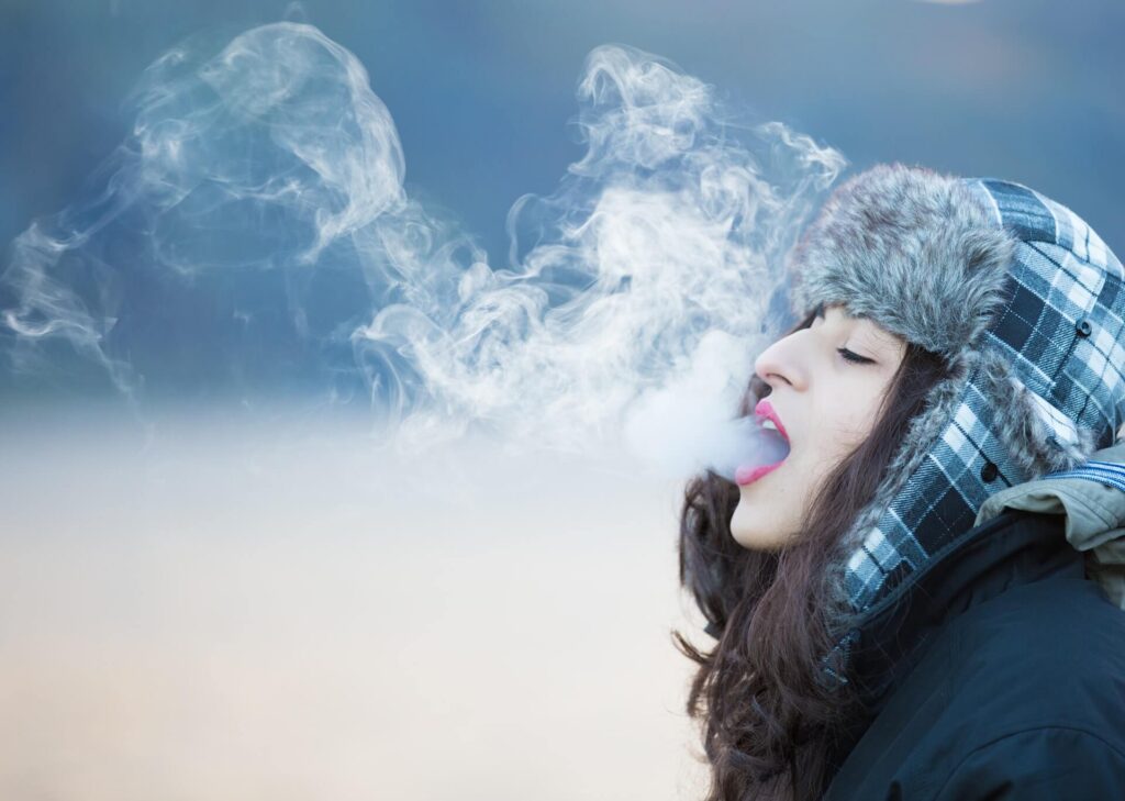 Woman with dark blue jacket with smoke